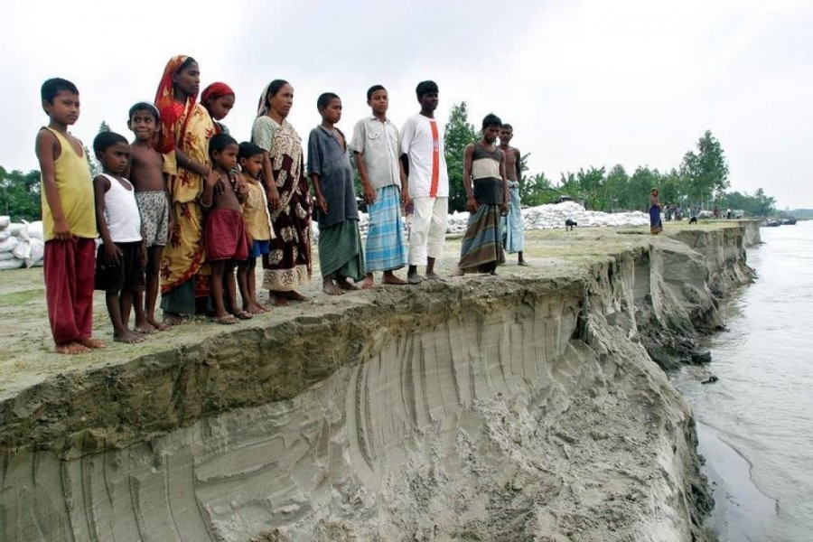 In this July 2004 file photo, Bangladeshis look at the erosion left by the river Jamuna, in Sariakandi, near Bogra town, 250 km northwest of the capital Dhaka. Reuters
