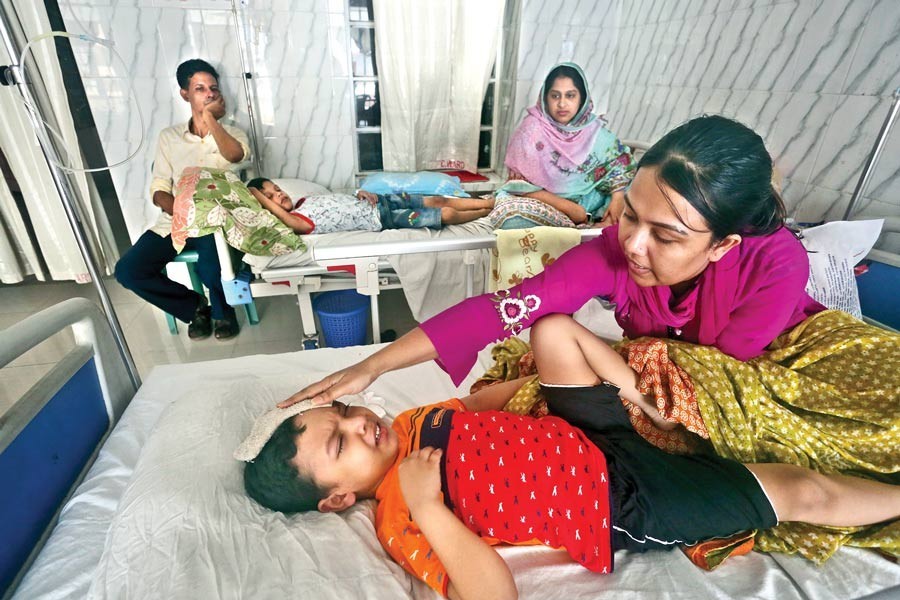 A mother nursing her son Afrahaf Khan Rusho undergoing treatment for dengue at Holy Family Red Crescent Medical College Hospital in the city on Friday — FE photo