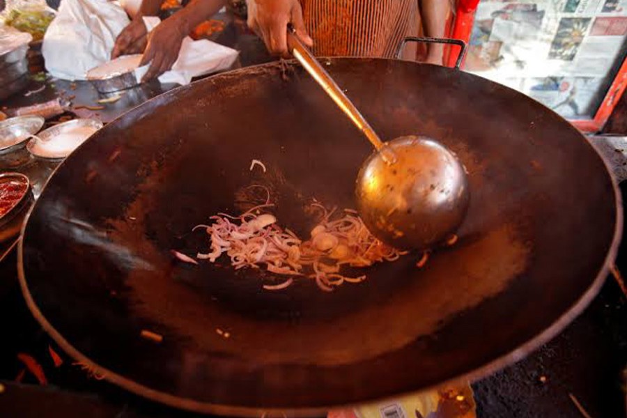 A cook fries onions to put into vegetable chowmein at a beachside restaurant in Mumbai, India, January 28, 2011. Reurters/Files