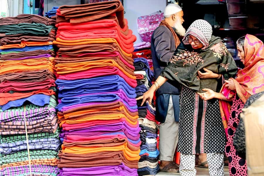 As temperature started dropping, blanket has become the most sought-after item for city dwellers. The photo shows two women buying blankets at a shop at Bangabazar on Wednesday — FE photo