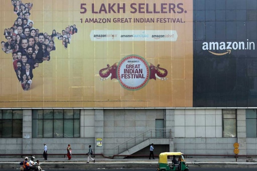 People move past a hoarding of Amazon India outside a metro rail station in New Delhi, India, October 23, 2019. Reuters/Files