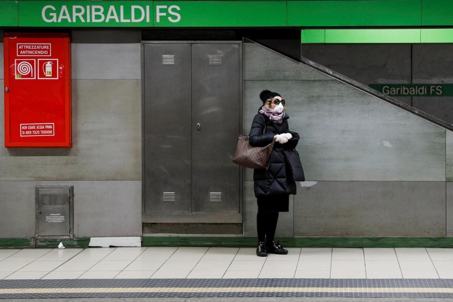 A woman wearing a protective face mask to prevent contracting the coronavirus waits for a train at the Garibaldi subway station in Milan, Italy, March 3, 2020. REUTERS/Guglielmo Mangiapane