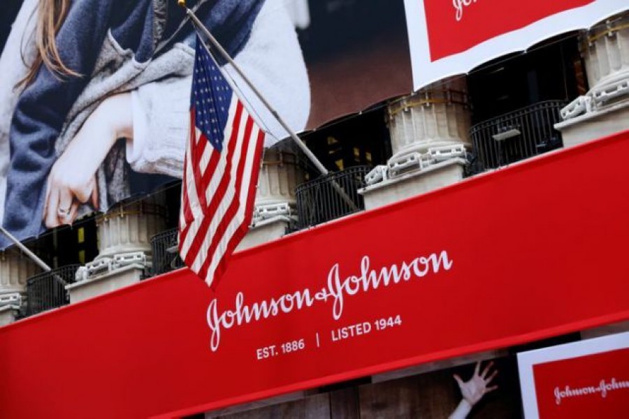 The US flag is seen over the company logo for Johnson & Johnson to celebrate the 75th anniversary of the company's listing at the New York Stock Exchange (NYSE) in New York, US, September 17, 2019. REUTERS/Brendan McDermid/File Photo
