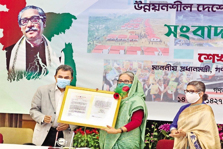 প্রধানমন্ত্রী শেখ হাসিনা শনিবার এক সংবাদ সম্মেলনে ‘স্বল্পোন্নত দেশ থেকে উন্নয়নশীল দেশে বাংলাদেশের উত্তরণ’-এর জাতিসংঘের চূড়ান্ত সুপারিশ অর্থমন্ত্রী আ হ ম মুস্তফা কামালের কাছে থেকে গ্রহণ করেন। ছবি: পিআইডি