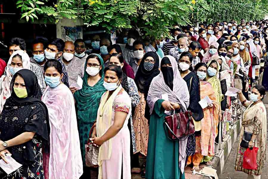 Maintaining social distancing is as important as getting vaccinated to prevent the spread of COVID-19, but these people stand so close to one another while waiting outside the Sarkari Karmachari Hospital at Fulbaria in the city on Wednesday to get inoculated, not giving a damn for the health safety protocols — FE photo