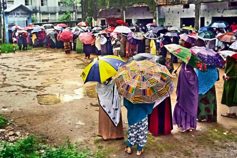 Braving rain, people crowd a vaccination centre at T & T High School at Agrabad in the port city of Chattogram to get their Covid-19 shot on Saturday, the first day of the mass inoculation programme in the country —FE Photo
