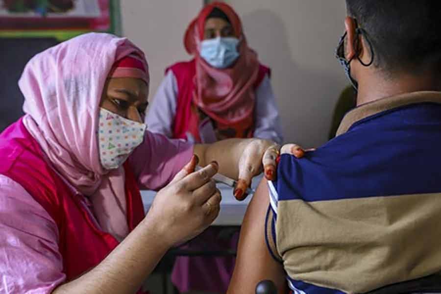 A person taking a dose of a coronavirus vaccine at a centre in Dhaka’s Hatirpool on Monday -bdnews24.com photo