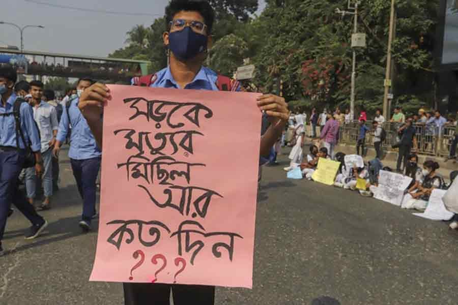 নটর ডেম কলেজের শিক্ষার্থী নাঈম হাসানের মৃত্যুর প্রতিবাদে শনিবার প্ল্যাকার্ড হাতে ধানমণ্ডির ২৭ নম্বর সড়কে বিক্ষোভ করে কয়েকটি শিক্ষা প্রতিষ্ঠানের শিক্ষার্থীরা। ছবি: বিডিনিউজ টোয়েন্টিফোর ডটকম।