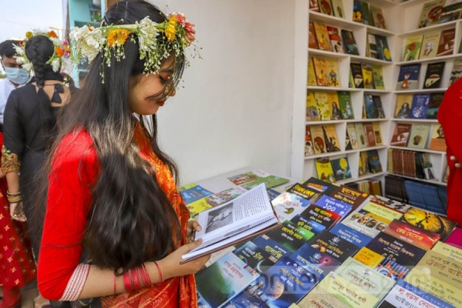 বইমেলার একটি স্টলে সোমবার বই দেখছেন একজন বইপ্রেমী।