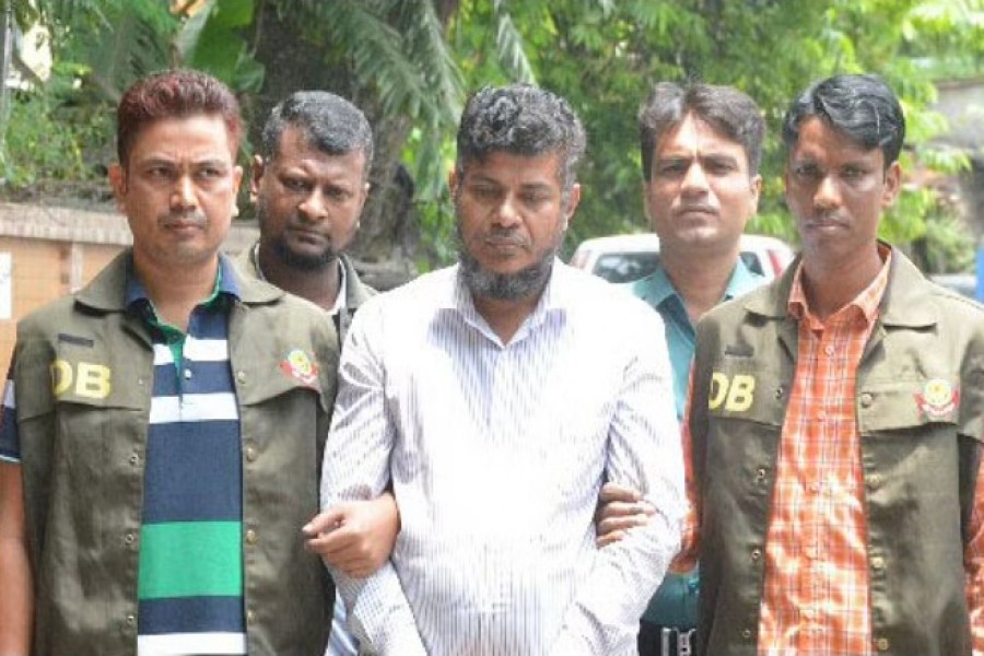 পুলিশের চাকরিচ্যুত এএসআই হুমায়ুন কবীর (মাঝে) জাল নোট চক্রে বলে জানিয়েছে ডিবি।ছবি: বিডিনিউজ টোয়েন্টিফোর ডটকম