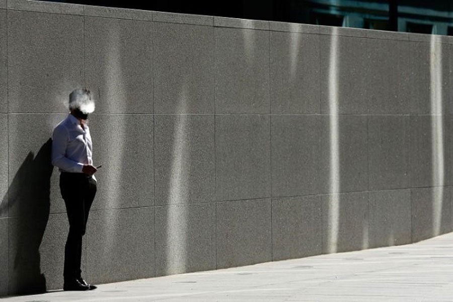 A man uses an electronic cigarette on a sunny spring day in London, April; 14, 2015. Reuters