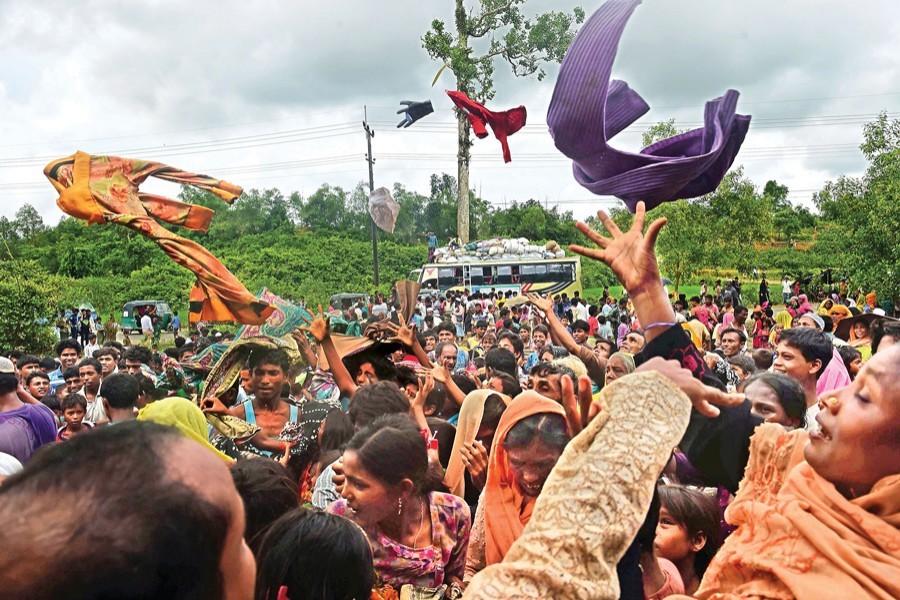 Rohingya refugees, who just arrived from Rakhine state of Myanmar, scramble for relief supplies at Kutupalong camp in Ukhia under Cox's Bazar on Saturday. — AFP