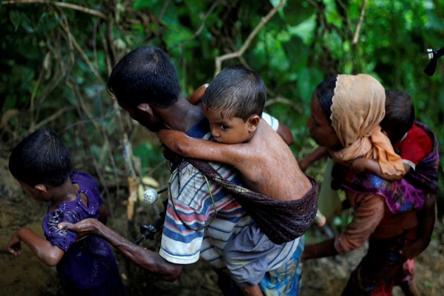 Rohingya refugees climb up a hill after crossing the Bangladesh-Myanmar border in Cox's Bazar, Bangladesh on Friday last. - Reuters photo