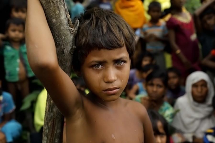 A Rohingya refugee girl looks next to newly arrived refugees who fled to Bangladesh from Myanmar - Internet photo