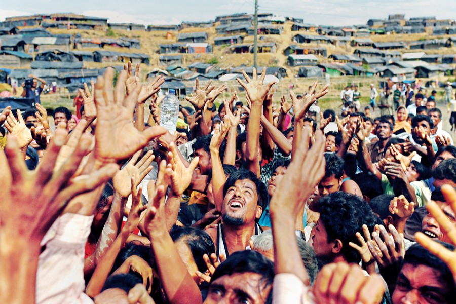 Rohingya refugees stretch their hands to receive aid, distributed by local organisations at the Balukhali makeshift refugee camp in Cox's Bazar on Thursday.  	— Reuters