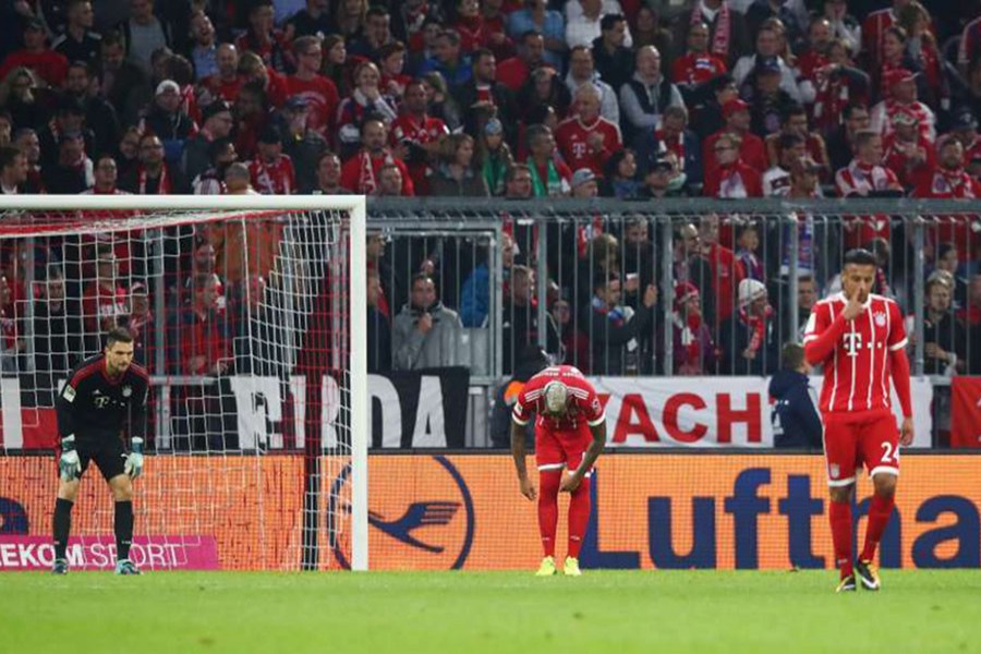 Bayern Munich players look dejected after Wolfsburg's Daniel Didavi scores their second goal. - Reuters photo