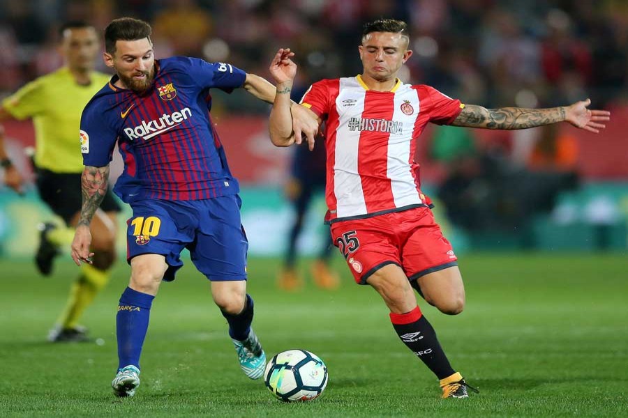 Barcelona's Lionel Messi in action with Girona's Pablo Maffeo during the Santander La Liga match between Girona and FC Barcelona at Estadi Montilivi stadium in Girona, Spain on Saturday. 	— Reuters