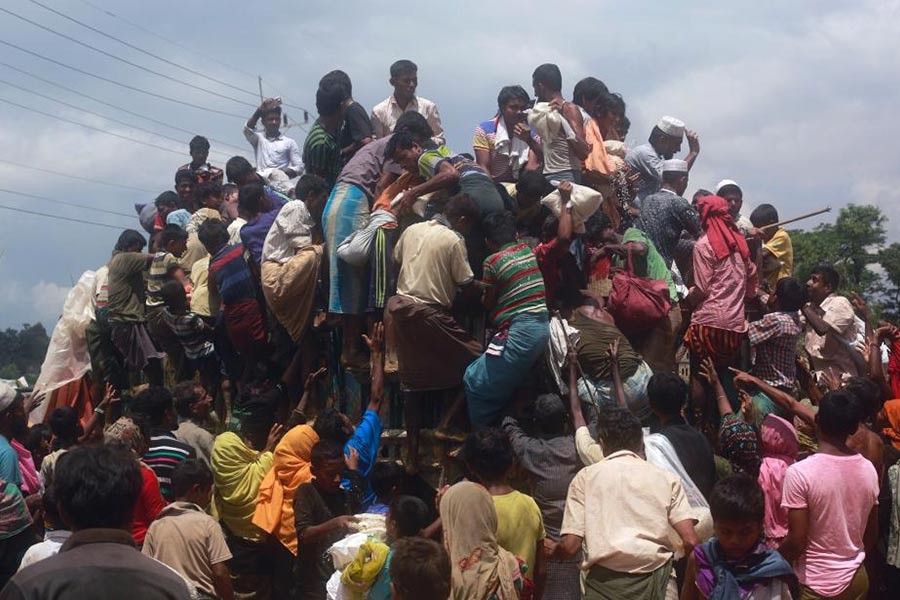 Rohingya refugees climb a truck to receive aid distributed by local organisations at Balukhali makeshift refugee camp in Cox's Bazar, Bangladesh, September 14, 2017. -Reuters Photo