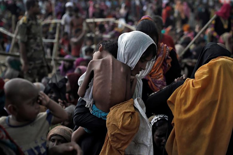 A woman carries her ill child in a refugee camp at Cox's Bazar, Bangladesh.  Approximately 480,000 Rohingya Muslims have fled to Bangladesh since August following an Army crackdown in Myanmar's Rakhine State.- Reuters photo