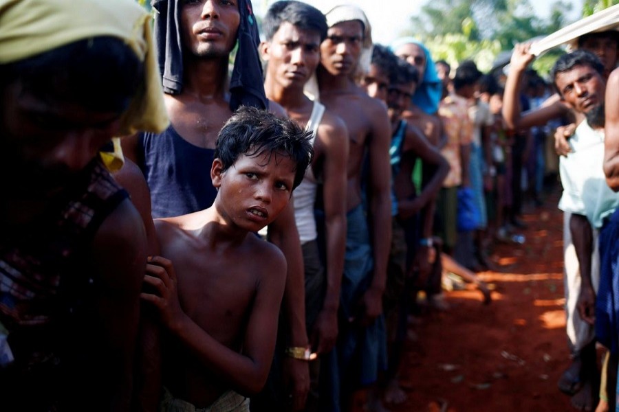 A Rohingya refugee boy looks on as he stands in a queue to receive relief supplies given by local people in Cox’s Bazar, Bangladesh September 16, 2017. Reuters