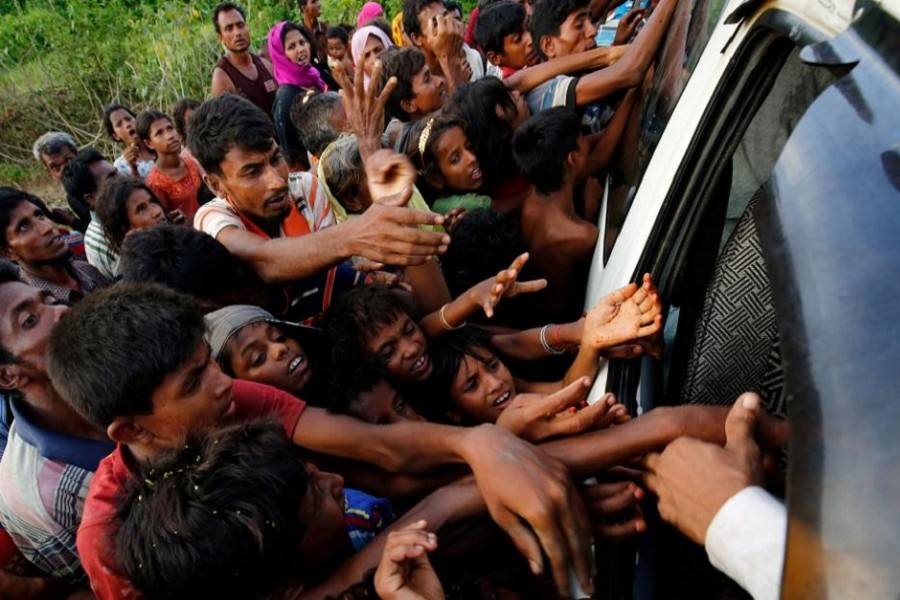 Rohingya refugees stretch their hands for food near Balukhali in Cox's Bazar, Bangladesh, September 4, 2017. Reuters