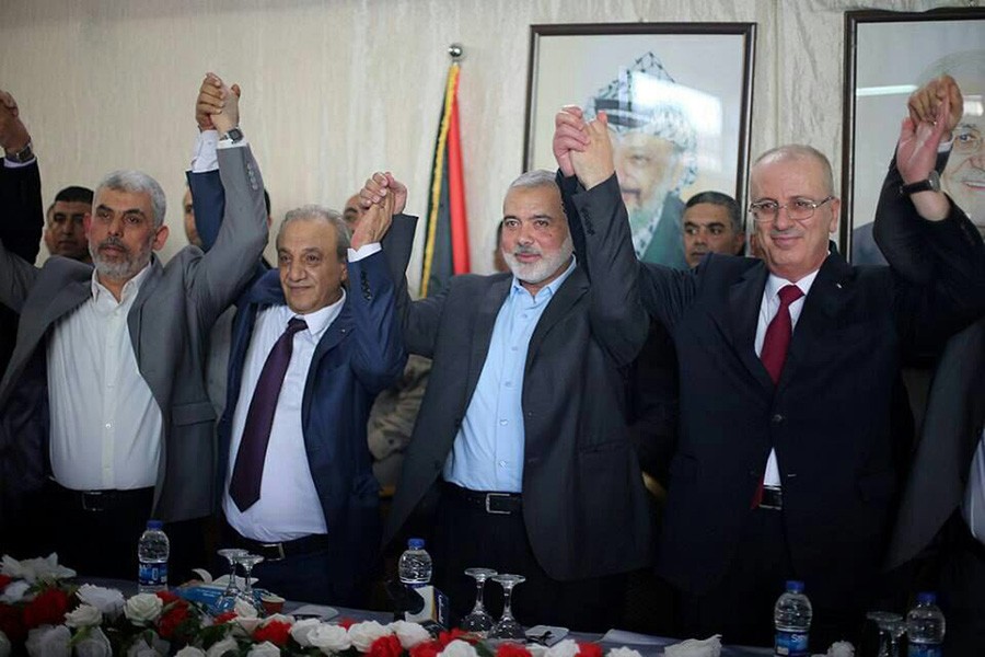 Palestinian Prime Minister Rami Hamdallah (R) and Hamas Chief Ismail Haniyeh hold hands in Gaza City on October 2 last. - Reuters file photo