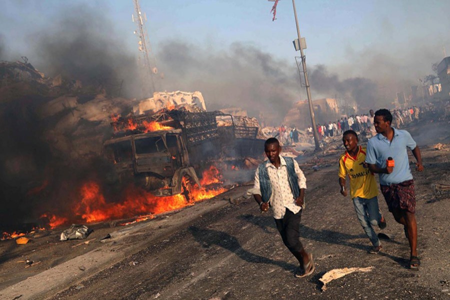 Civilians evacuate from the scene of an explosion in KM4 street in the Hodan district of Mogadishu, Somalia on Saturday. - Reuters photo