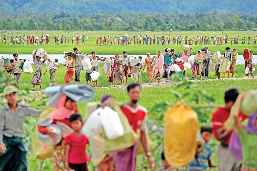 Rohingya refugees, who crossed the border from Myanmar two days before, walk to the refugee camps in Palang Khali, near Cox's Bazar, on Thursday as the Bangladesh Army allowed them in. 	— Reuters