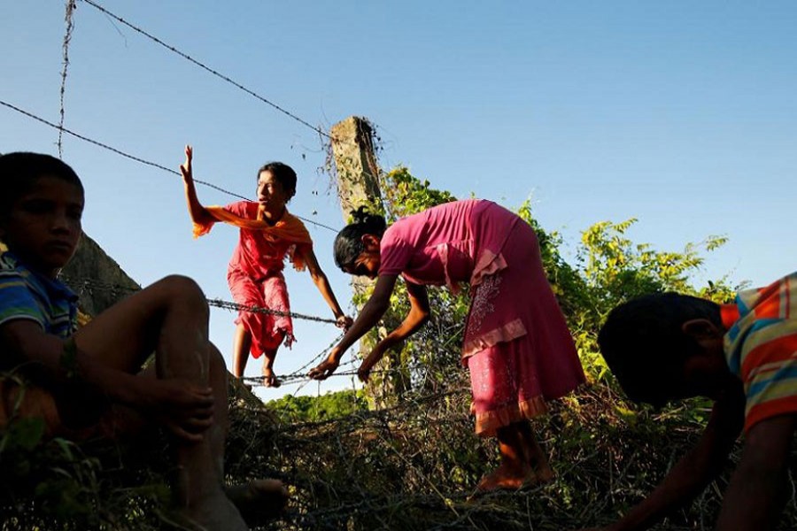 Rohingya children cross the Bangladesh-Myanmar border fence as they try to enter Bangladesh in Bandarban, an area under Cox's Bazar authority, Bangladesh, August 29, 2017. Reuters