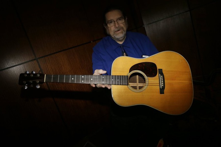 Garry Shrum, a music memorabilia specialist at Heritage Auctions, displays an acoustic guitar that belonged to Bob Dylan in Dallas, on October 13 last. - AP photo