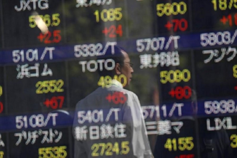 Passersby are reflected in an electronic stock quotation board outside a brokerage in Tokyo, Japan, October 23, 2017. Reuters