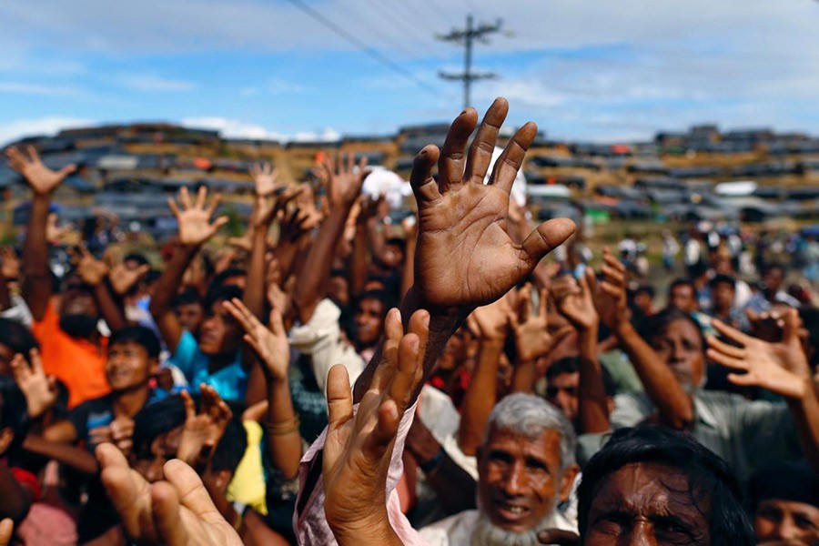 Rohingya refugees stretch their hands to receive aid distributed by local organisations at Balukhali makeshift refugee camp in Cox's Bazar, Bangladesh on September 14 last. - Reuters file photo