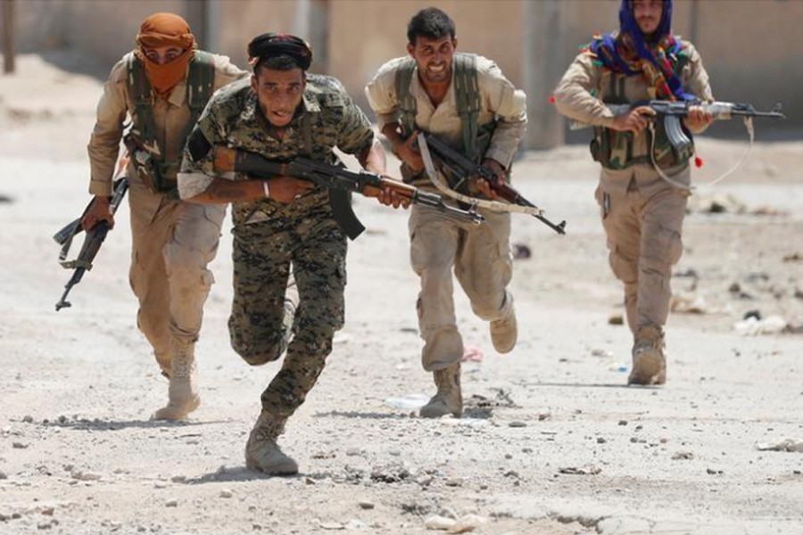 urdish fighters from the People's Protection Units  run across a street in Raqqa, Syria July 3, 2017. REUTERS