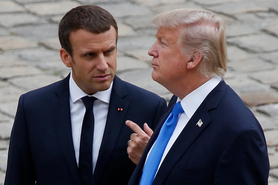 French President Emmanuel Macron and US President Donald Trump walk in the courtyard as they leave after a welcoming ceremony at the Invalides in Paris, France. - Reuters