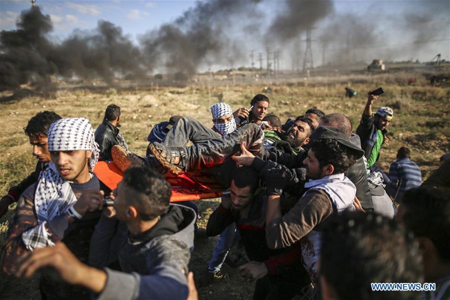 A wounded Palestinian protester is evacuated during clashes with Israeli troops after a protest against U.S. recognition of Jerusalem as Israeli capital, near east of Gaza city, on Friday, photo: Xinhua.