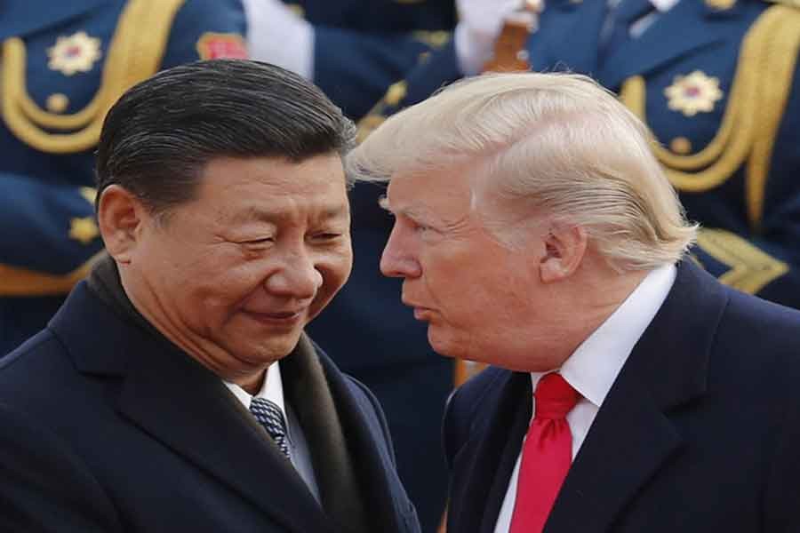 US President Donald Trump chats with Chinese President Xi Jinping during a welcome ceremony in Beijing on November 09, 2017. – Photo: AP