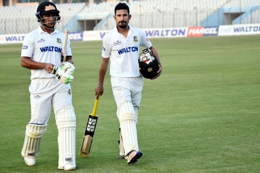 Rangpur Division's Ariful Haque (left) and Nasir Hossain walk back to the pavilion at the end of third day of the 19th National Cricket League (NCL) held at Zahur Ahmed Chowdhury Stadium in Chittagong on Friday. 	— bdnews24.com