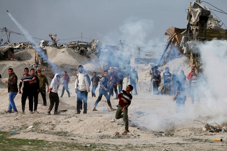 A Palestinian demonstrator hurls back a tear gas canister fired by Israeli troops, during clashes at a protest near the border with Israel in the east of Gaza City on Friday. - Reuters photo