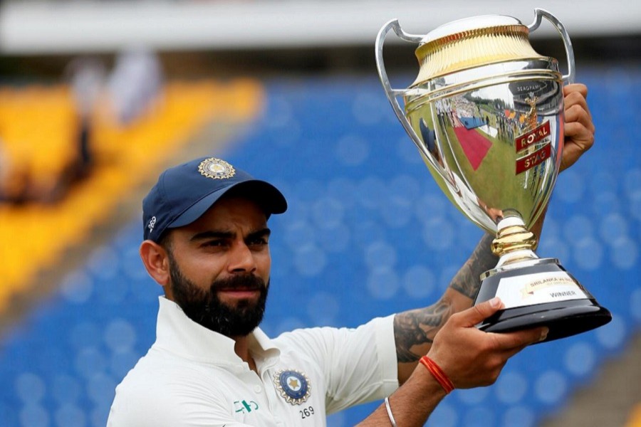 India's captain Virat Kohli holds the trophy for photographs after they won the match and test cricket series against Sri Lanka. Reuters