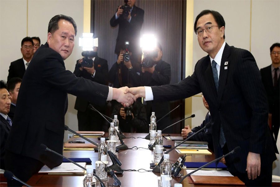 Head of N Korean delegation, Ri Son Gwon shakes hands with S Korean counterpart Cho Myoung-gyon as they exchange documents after their meeting January 9, 2018. Photo: Reuters