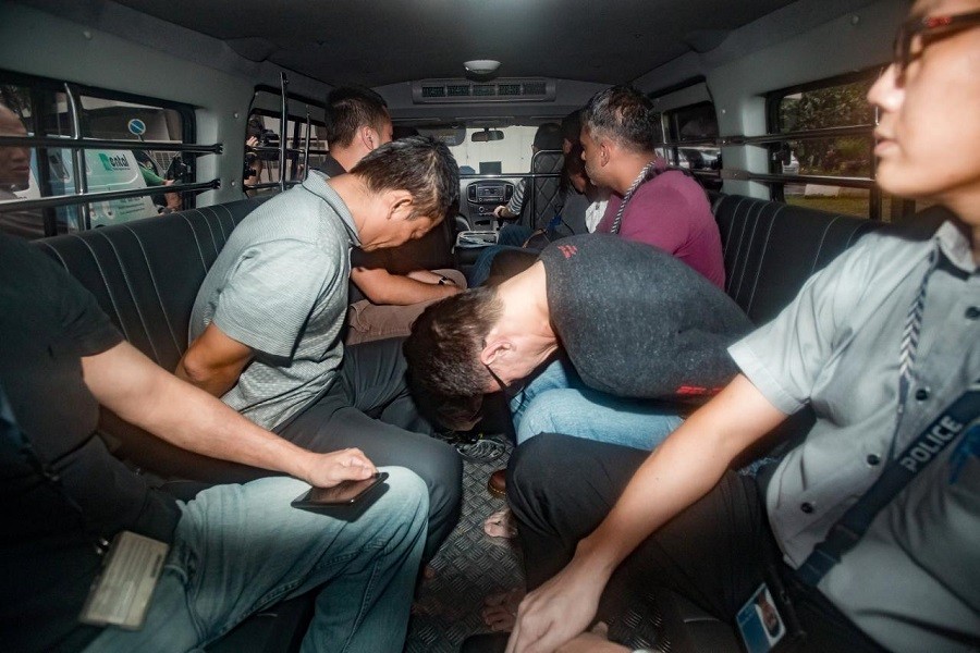 Suspects, part of a group of 17 detained over their part in an alleged oil theft at Shell's Pulau Bukom refinery, arrive in a van at the State Courts, Singapore January 13, 2018. Reuters