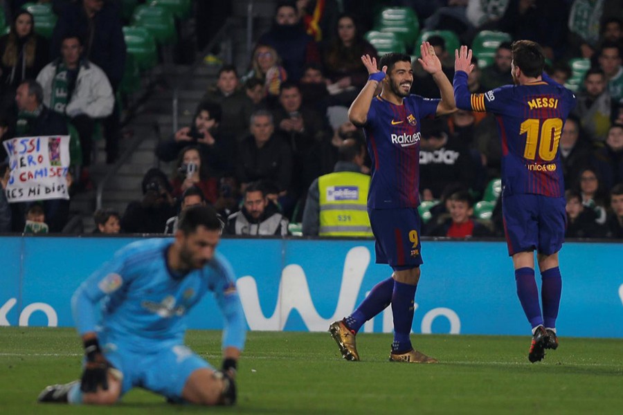 Luis Suarez celebrates scoring Barcelona's fifth goal with Lionel Messi while Real Betis' Antonio Adan cuts a dejected figure. - Reuters photo