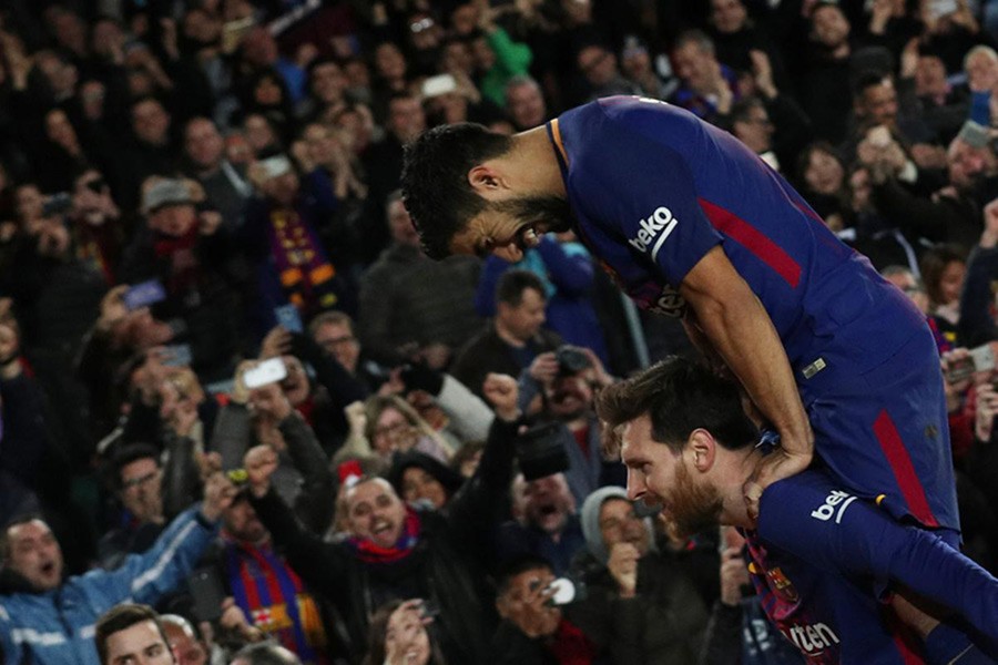 Barcelona’s Lionel Messi celebrates scoring their second goal with Luis Suarez on Sunday. - Reuters photo