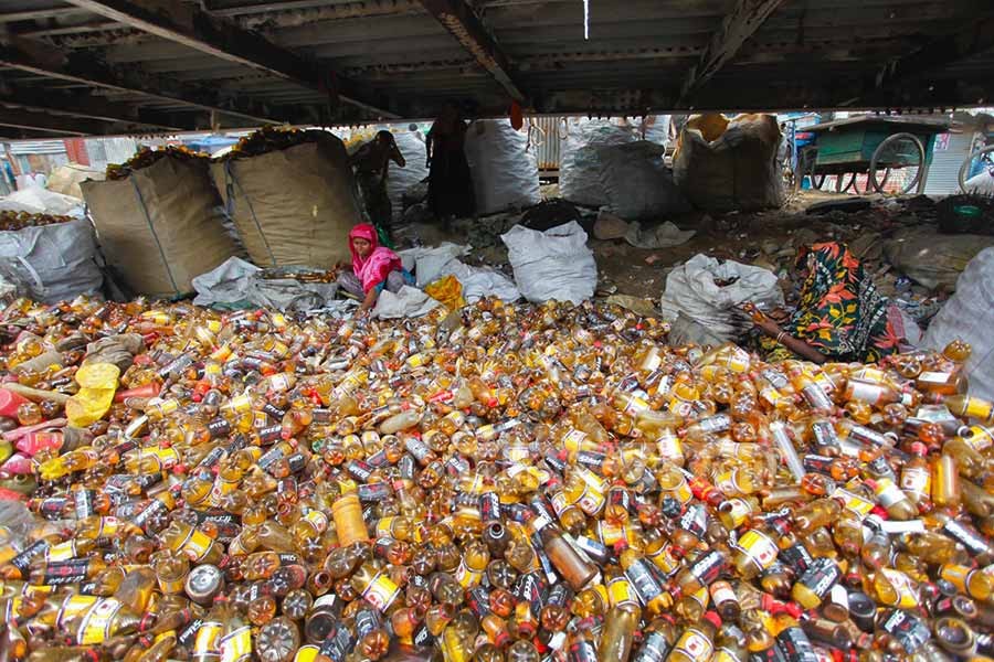 Workers busy working in a plastic factory located near a tributary of Buriganga in Dhaka. Photo: bdnews24.com