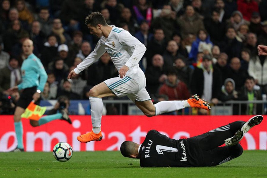 Real Madrid's Cristiano Ronaldo in action with Real Sociedad's Geronimo Rulli. - Reuters photo