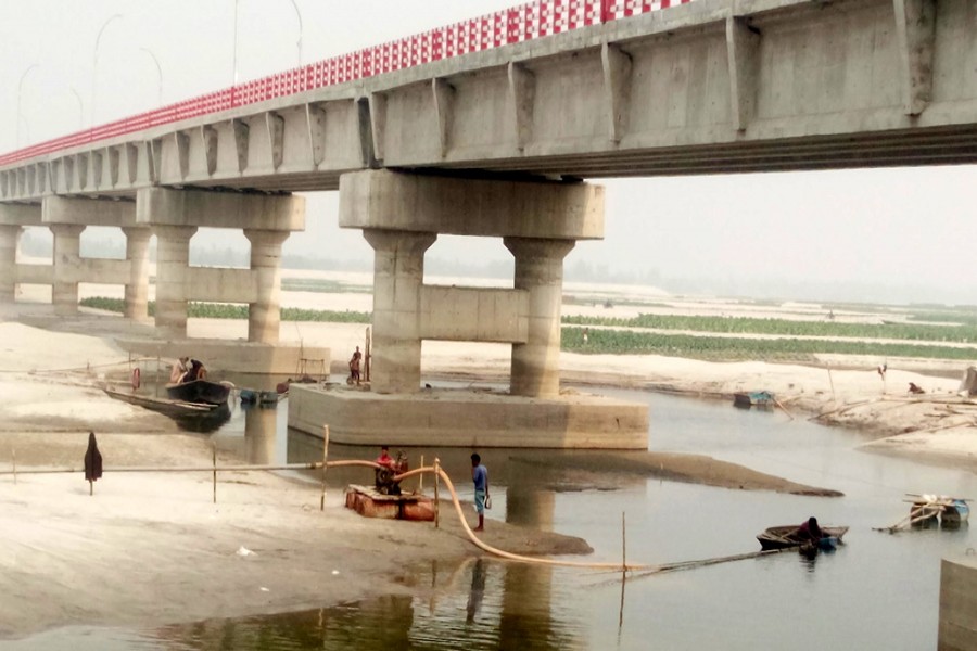 Unauthorised sand lifting from the Teesta poses a threat to the second Teesta Bridge in Mahipur area under Gangachara upazila of Rangpur. 	— FE Photo