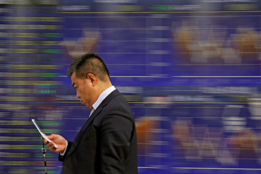 A man walks past an electronic stock quotation board outside a brokerage in Tokyo, Japan on February 9. Reuters