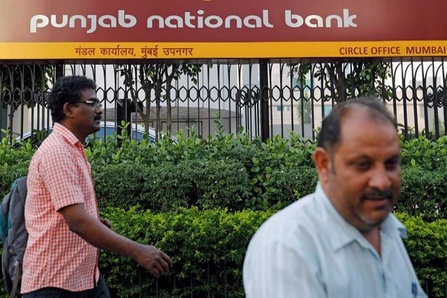 Pedestrians walk past a Punjab National Bank office in Mumbai, India February 21, 2018. Reuters