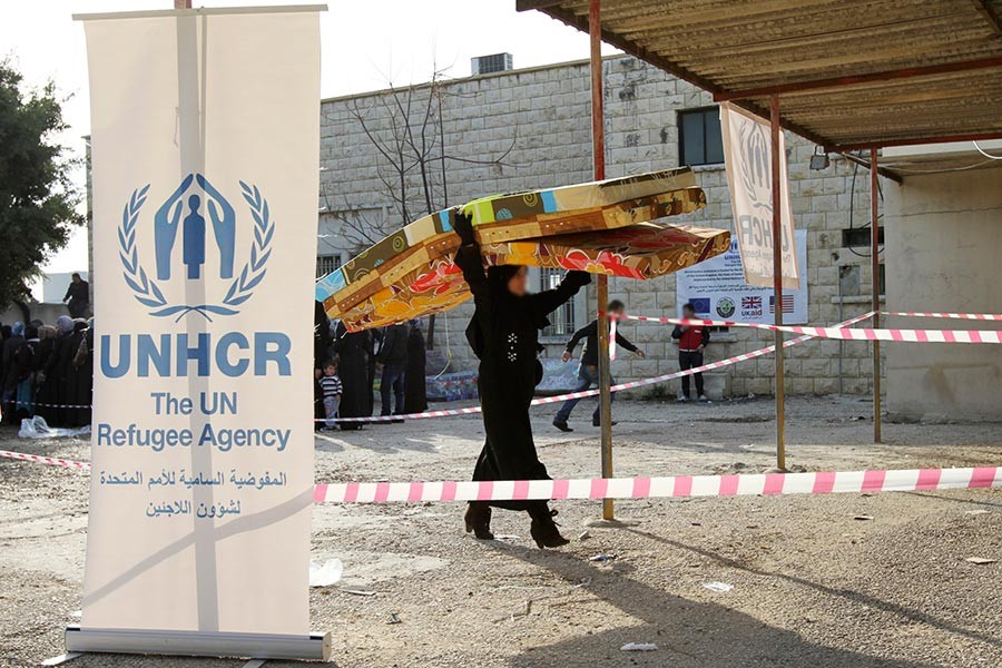 A Syrian refugee receives aid from the UN refugee agency (UNHCR) in Batroun, northern Lebanon January 13, 2015. - Reuters file photo