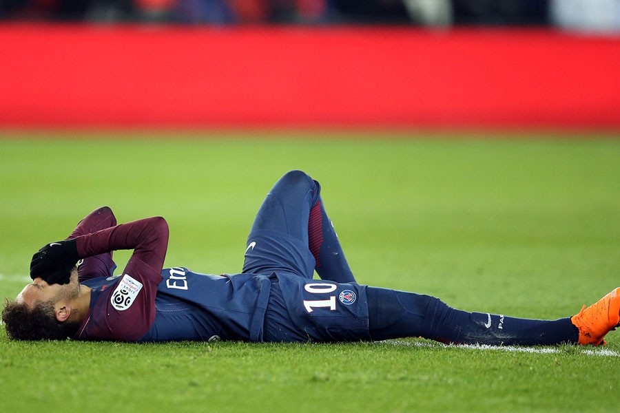 Paris Saint-Germain’s Neymar lies on the pitch after sustaining an injury. Reuters.